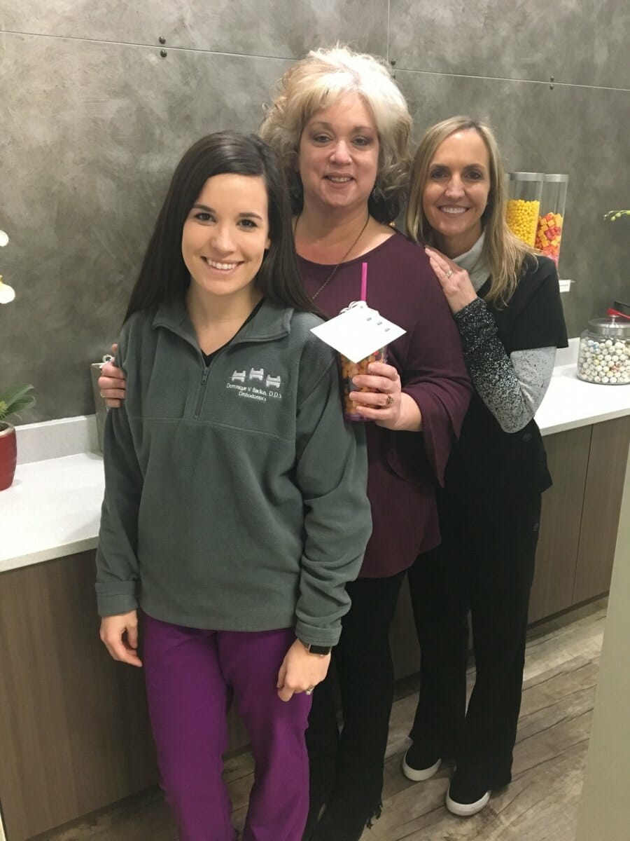 Happy patient with Dr. Backus and a team member after she got her braces off, Backus Smiles